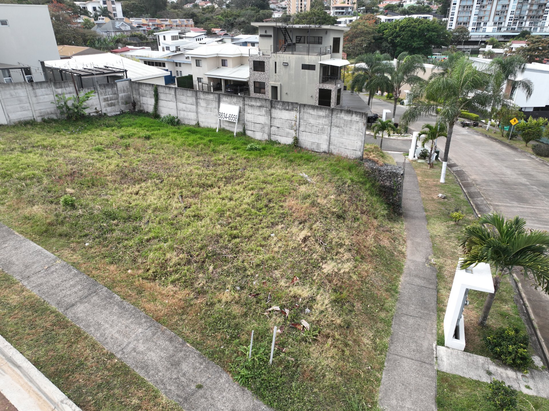 Vista elevada del lote esquinero de 338 m² con doble frente en Rivergrand, Escazú