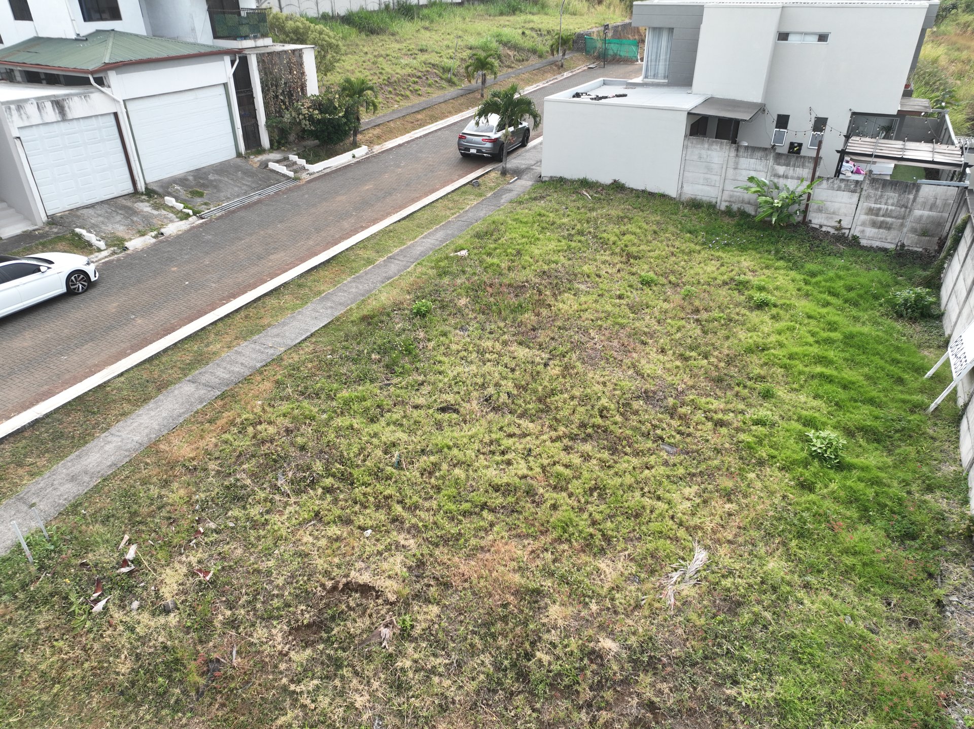 Vista aérea cenital del lote esquinero de 338 m² y calles adoquinadas en Rivergrand